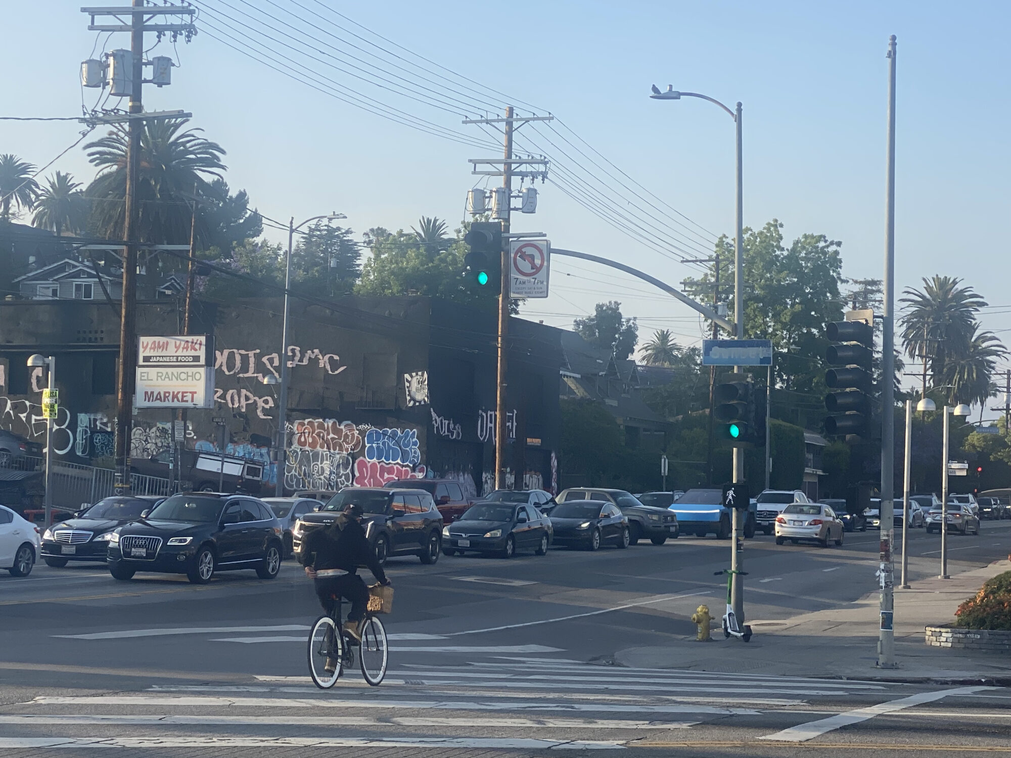 Vehicle traffic along Alvarado Street at Sunset Boulevard. Cyclist in the foreground.